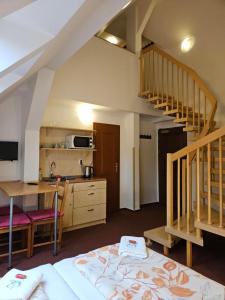 a room with a bed and a kitchen with a staircase at Marianum JL,s.r.o. in Janske Lazne