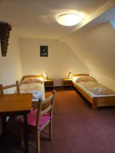 a room with two beds and a table and a desk at Marianum JL,s.r.o. in Janske Lazne