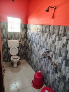 baño con aseo y 2 grifos en Hotel Saksham, en Pākaur