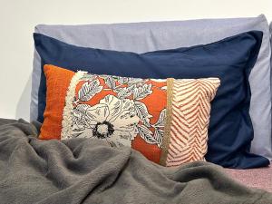 a pile of pillows sitting on top of a bed at Malpensa Airport Apartment - 9 min to MXP - Free Parking in Somma Lombardo +11 photos