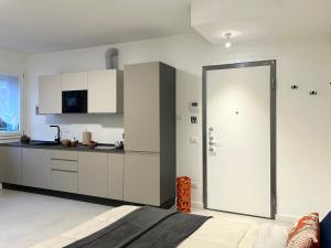 uma cozinha com armários brancos e uma porta de correr em Tilahome - Malpensa Apartment em Somma Lombardo