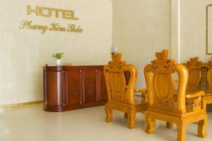 a room with two chairs and a hotel sign on the wall at Phụng Kim Thảo Hotel Long An in Long An