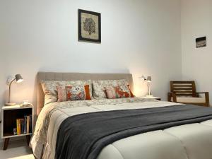 um quarto com uma cama grande e almofadas em Tilahome - Malpensa Apartment em Somma Lombardo