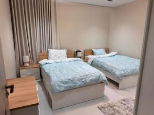 a bedroom with two beds with blue comforters at شقة قباء in Medina