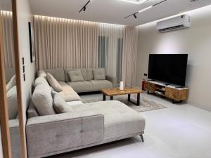 a living room with a couch and a flat screen tv at شقة قباء in Medina