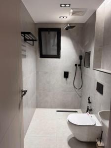 a white bathroom with a toilet and a sink at شقة قباء in Medina +21 photos