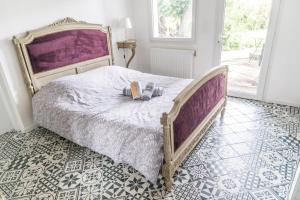 ein Schlafzimmer mit einem großen Bett mit einer lila Tagesdecke in der Unterkunft Appartement avec Jardin in Gerzat