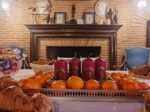 Château de Thégra في بالما: طاولة عليها برتقال وشموع موضوعة على طاولة بجانب مدفأة +16 صورة