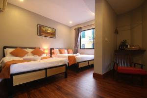 a hotel room with two beds and a window at Ostro Hotel in Phnom Penh +33 photos