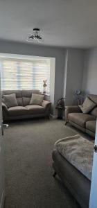 Hart's Place في Broughton Astley: غرفة معيشة مع أريكتين وأريكة