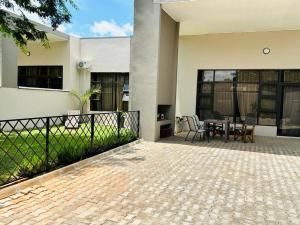 a patio of a house with a table and chairs at Longhorn Executive Apartments in Lusaka