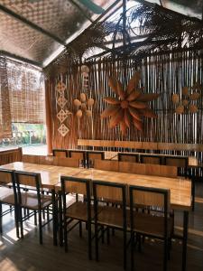 a dining room with a wooden table and chairs at Là Nhà Homestay in Hữu Lũng