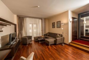 a living room with a couch and a tv at Art Passage Hotel in Baku