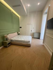 extra luxury apartment salerno center في ساليرنو: غرفة نوم مع سرير جلوس على أرضية خشبية