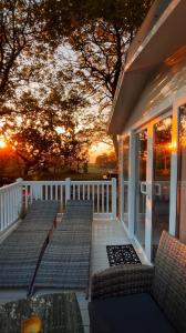 a porch with chairs and a sunset in the background at Ribble Heights Lodge - Cosy Pet-Free Countryside Retreat in Longridge