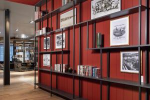 a library with red walls and shelves with books at Canopy By Hilton Ithaca Downtown in Ithaca