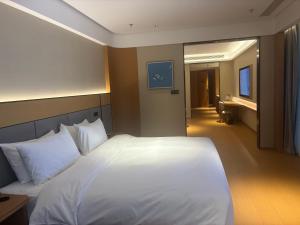 ein Schlafzimmer mit einem weißen Bett und ein Badezimmer in der Unterkunft JI Hotel Nanjing Qinhuai Baixia High-tech Industrial Park in Nanjing