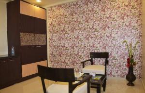 uma sala de estar com uma parede com flores rosas em Krushnai Resort em Kharakvasla
