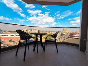 a balcony with a table and two chairs and a large window at Hiper Suites Residance in Antalya
