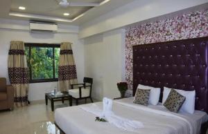 um quarto com uma cama grande com uma cabeceira grande em Krushnai Resort em Kharakvasla mais 7 fotografias