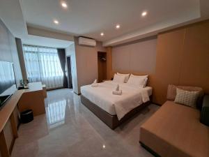 een grote slaapkamer met een bed en een bank bij Velin Pattaya Hotel in Ban Nong Chaeng +11 foto's