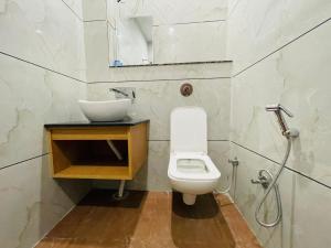 a bathroom with a white toilet and a sink at Hotel Pilgrim Near Golden Temple in Amritsar