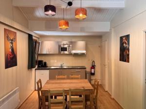 a kitchen with a table and chairs in a room at Orée du Bois in Petit Mesnil