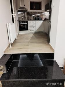 una cucina con pavimento in legno e frigorifero di Feggaropetra a Kalívia