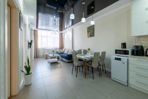 a kitchen and living room with a table and a couch at Luxury 2 Bedrooms Apartment with 2 bathrooms & Batumi center in Batumi