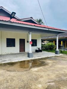 una casa con un charco de agua delante de ella en Hashim Homestay ISV 01003, en Mersing