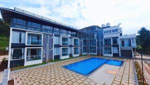 een huis met een zwembad ervoor bij Veera Resort in Attigundi