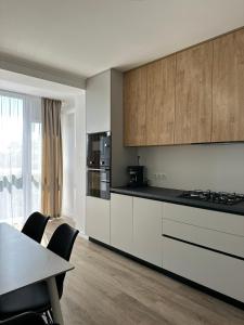 a kitchen with white cabinets and a table with chairs at White loft ЖК Престиж in Ternopilʼ +8 photos