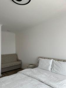 a white bedroom with a bed and a couch at White loft ЖК Престиж in Ternopilʼ