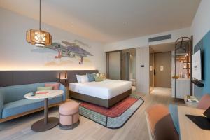 a hotel room with a bed and a couch at Capri by Fraser, Penang in George Town +15 photos