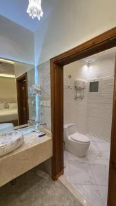 a bathroom with a tub and a toilet and a sink at Rox Luxury Hotel - روكس الفاخرة in Taif