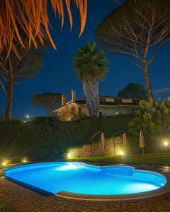 een blauw zwembad met een palmboom bij Villa Roma Open Space - Location per eventi 2 piscine riscaldate - in Rome