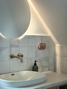 a bathroom with a white sink and a light at Na Pańskim in Klimkówka
