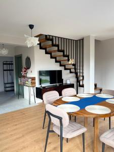 a living room with a table and chairs and a staircase at Na Pańskim in Klimkówka +15 photos