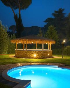 een zwembad met een prieel in de nacht bij Villa Roma Open Space - Location per eventi 2 piscine riscaldate - in Rome +17 foto's