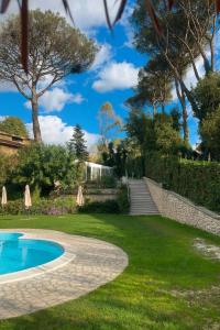 een tuin met een zwembad en een gazon bij Villa Roma Open Space - Location per eventi 2 piscine riscaldate - in Rome