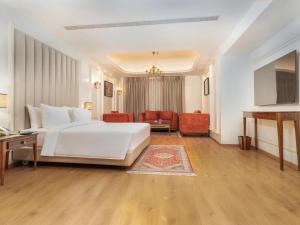 Un dormitorio con una cama blanca y una sala de estar. en Sarovar Premiere Srinagar, en Srinagar