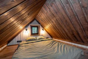 Metsamaja Põhja-Kõrvemaal : غرفة نوم بسرير كبير في سقف خشبي