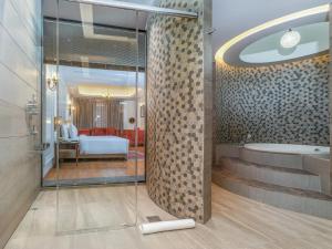 a bathroom with a tub and a bedroom at Sarovar Premiere Srinagar in Srinagar +42 photos