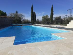 ein Swimmingpool mit blauem Wasser in einem Hof in der Unterkunft Gîte de charme la Fenière in Joyeuse + 8 Fotos