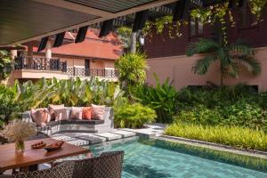 an outdoor patio with a pool and a table and chairs at Anantara Hua Hin Resort in Hua Hin