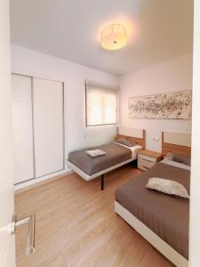 a bedroom with two beds and a window at LaMata Apartament in La Mata