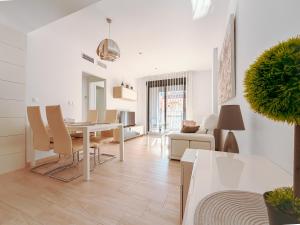 a white living room with a table and chairs at LaMata Apartament in La Mata