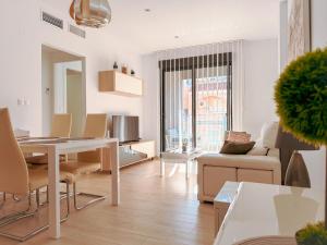 a white living room with a table and chairs at LaMata Apartament in La Mata +6 photos