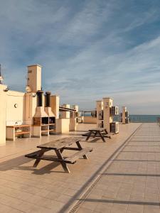 a group of picnic tables on the roof of a building at LaMata Apartament in La Mata
