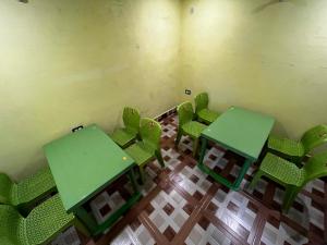 an empty room with green tables and chairs at Sawra Homestay in Chakrāta